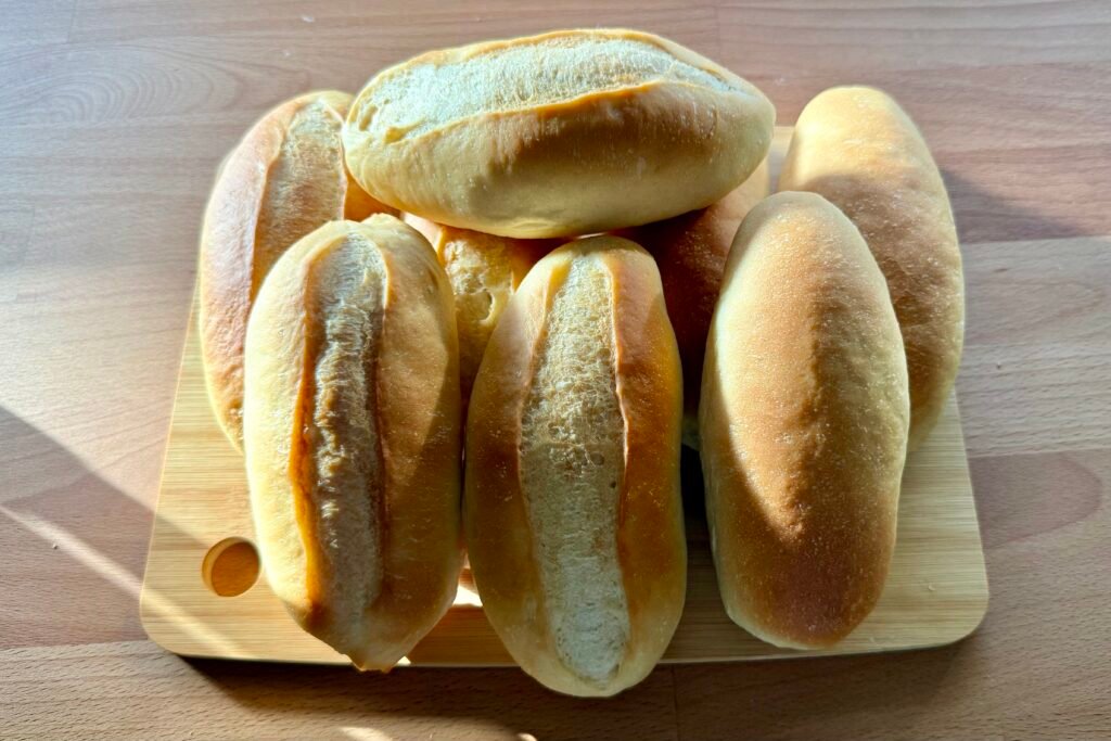 Panecillos tiernos para bocadillos recién horneados sobre una tabla de madera